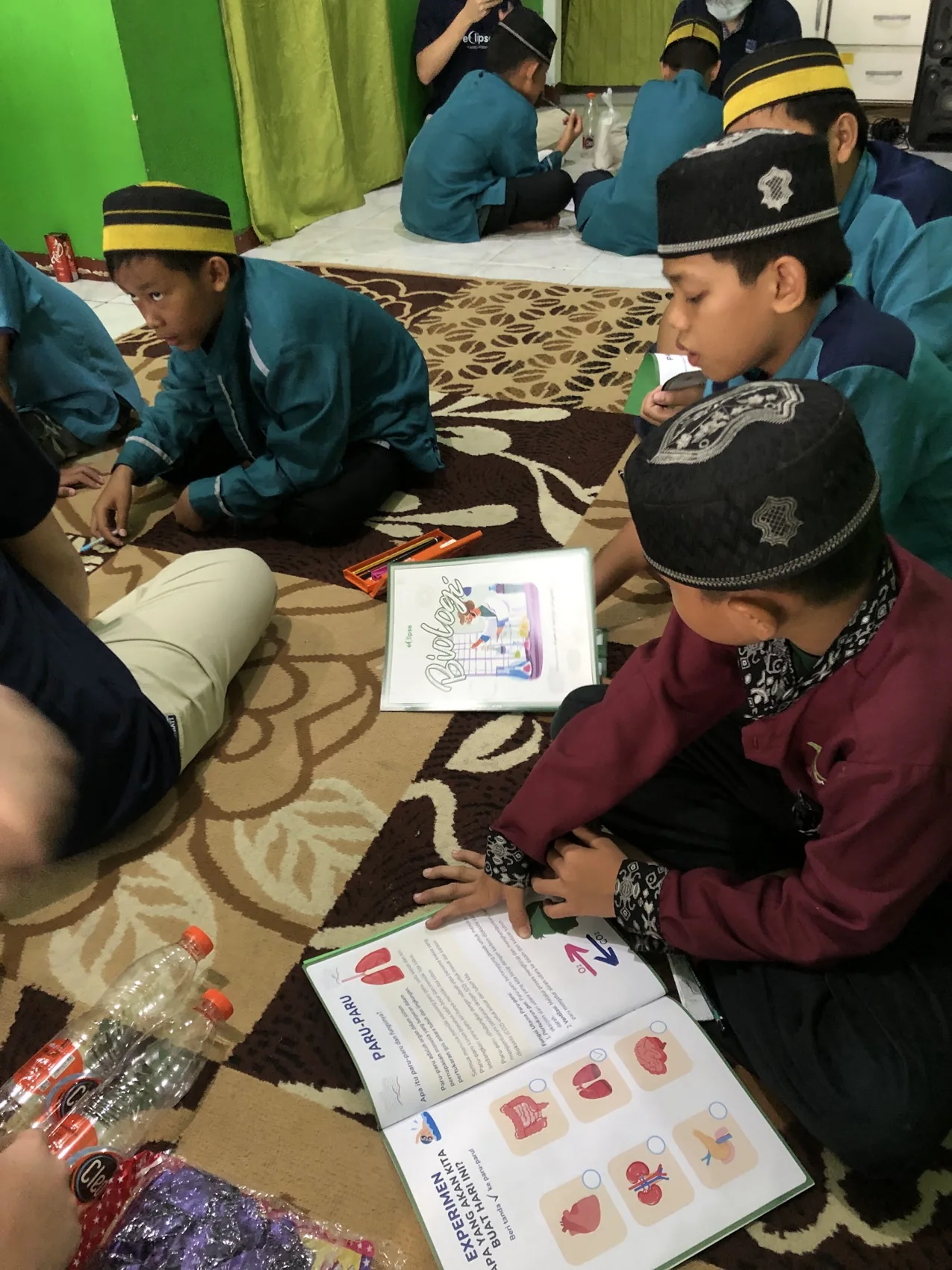 Learners holding and looking through illustrated workbooks.