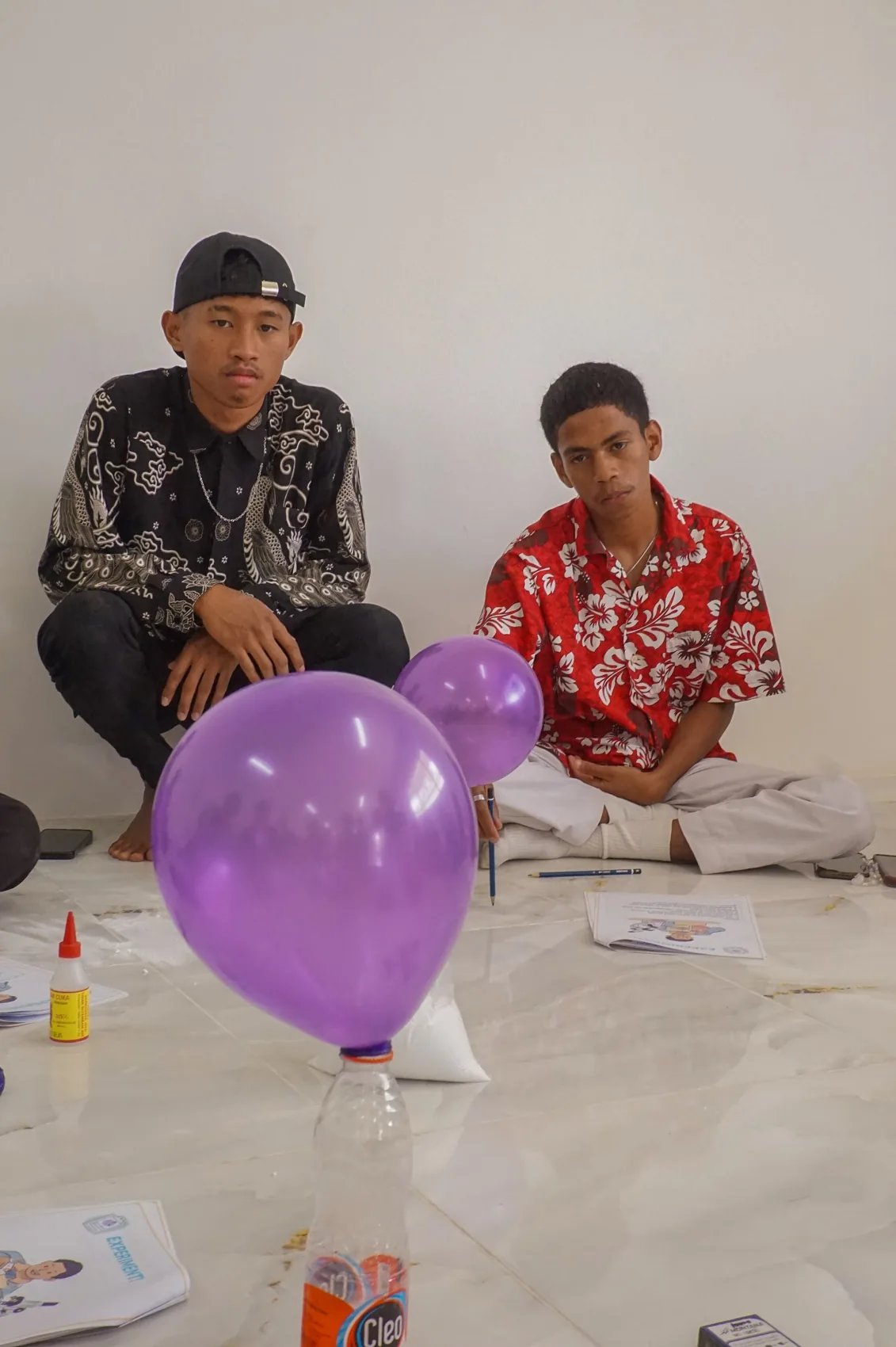 Participants sitting beside purple balloons during an activity.
