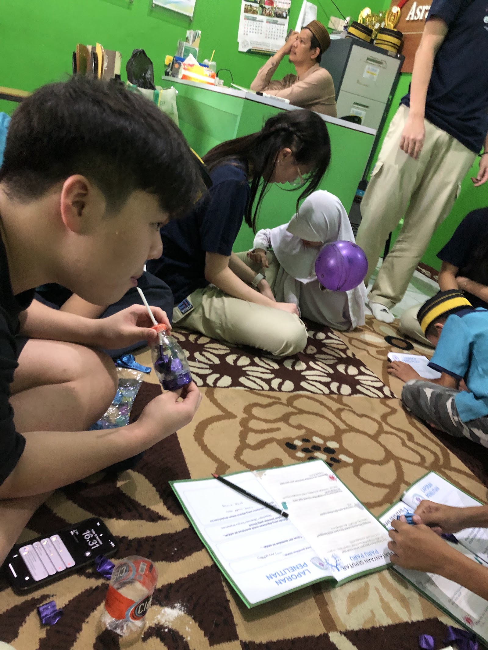 A volunteer guiding a practical activity on the floor