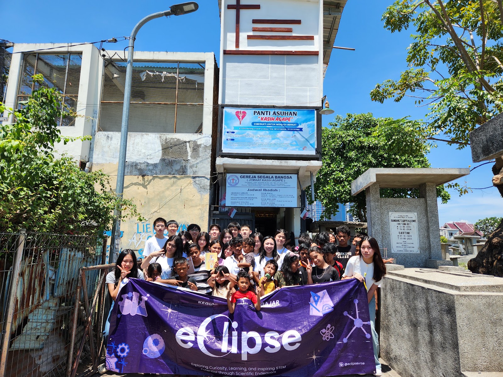 Children and volunteers gathered with the EclipseLearns banner