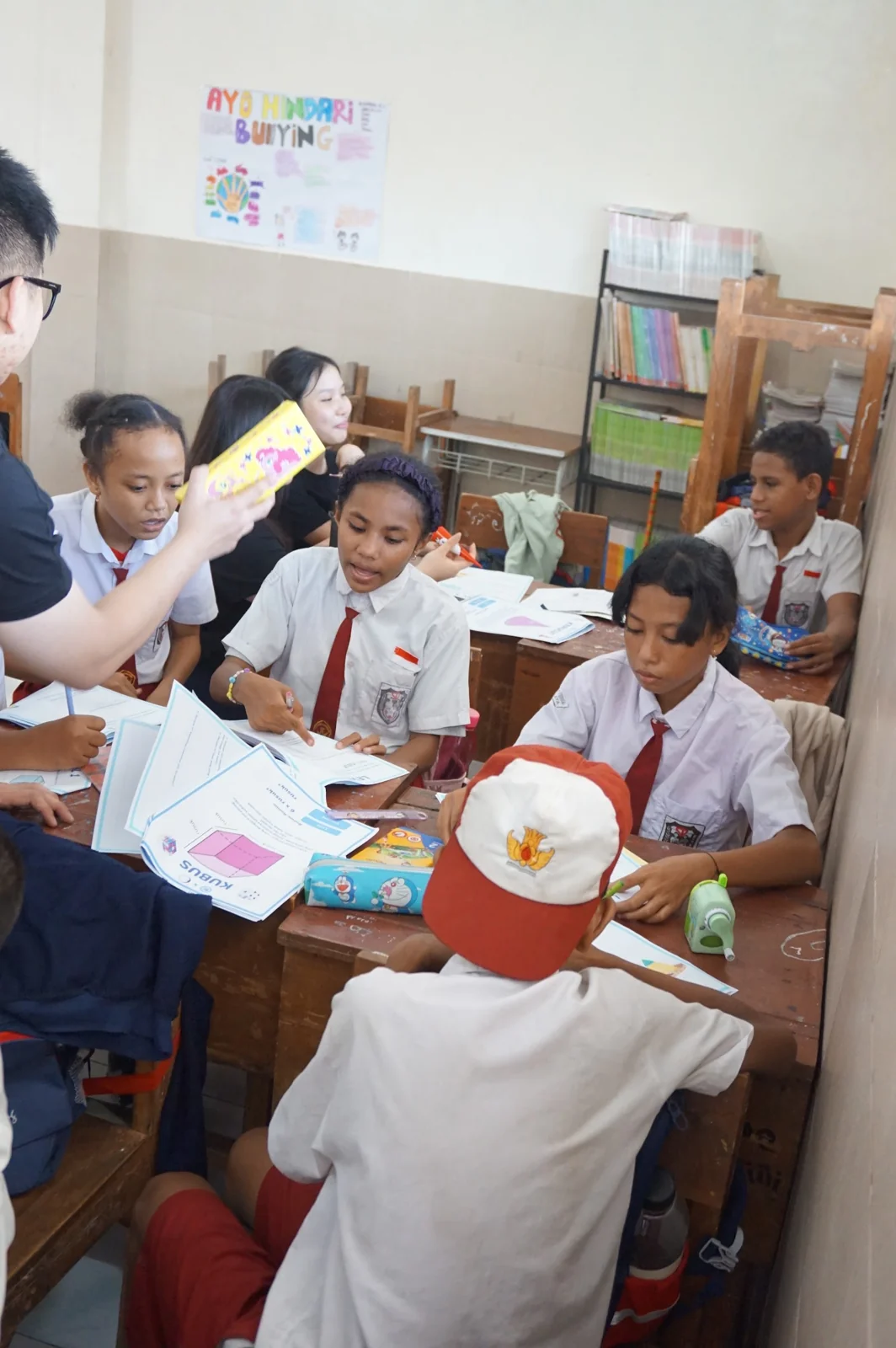 Students using illustrated STEMEdu workbooks alongside volunteers